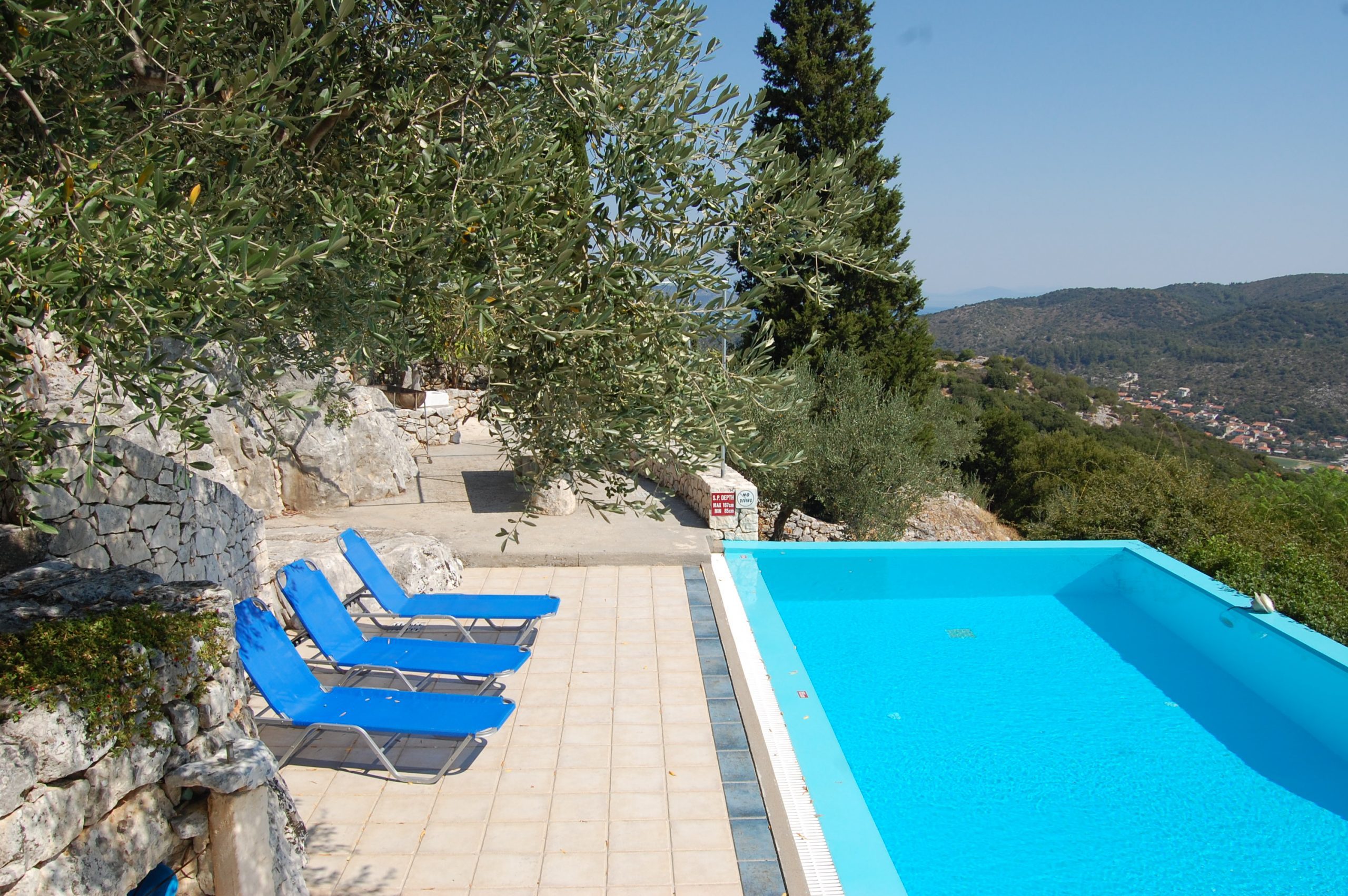 Swimming pool and stone terrace with view of property for sale in Ithaca Greece Perachori