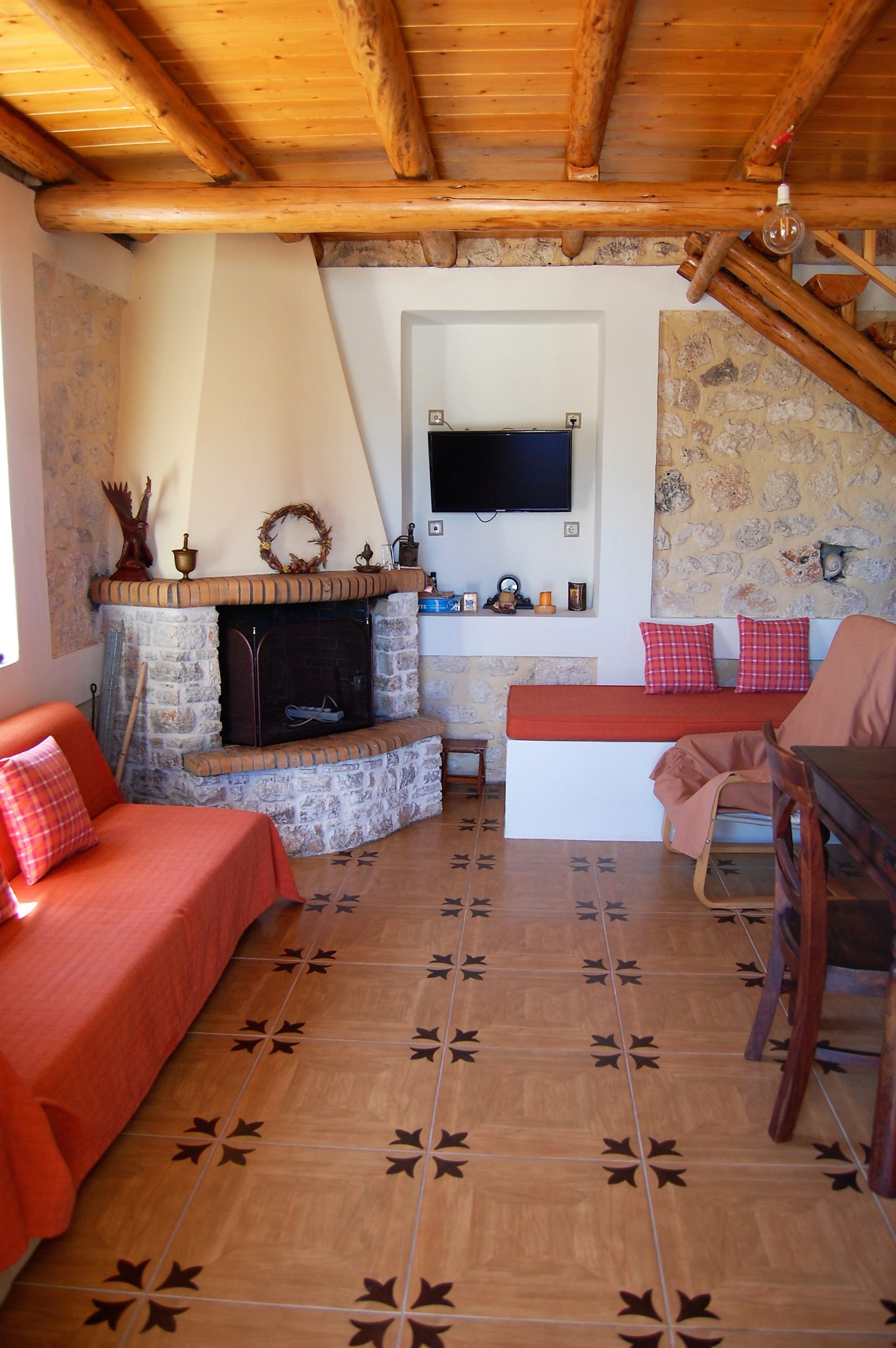 Open plan lounge with fireplace of stone house for rent Ithaca Greece