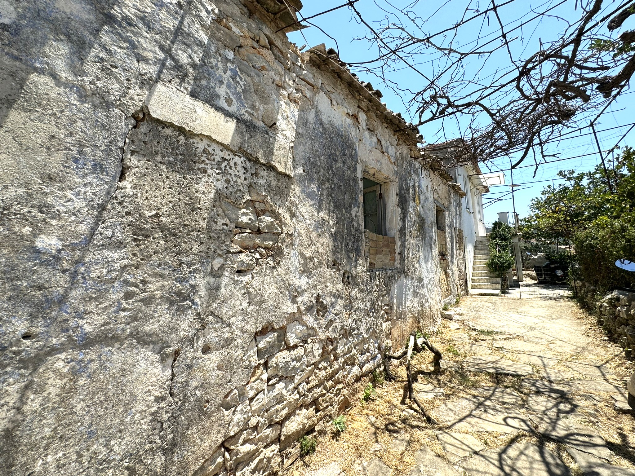 External wall of house and path view of house for sale in Ithaca Greece Vathi