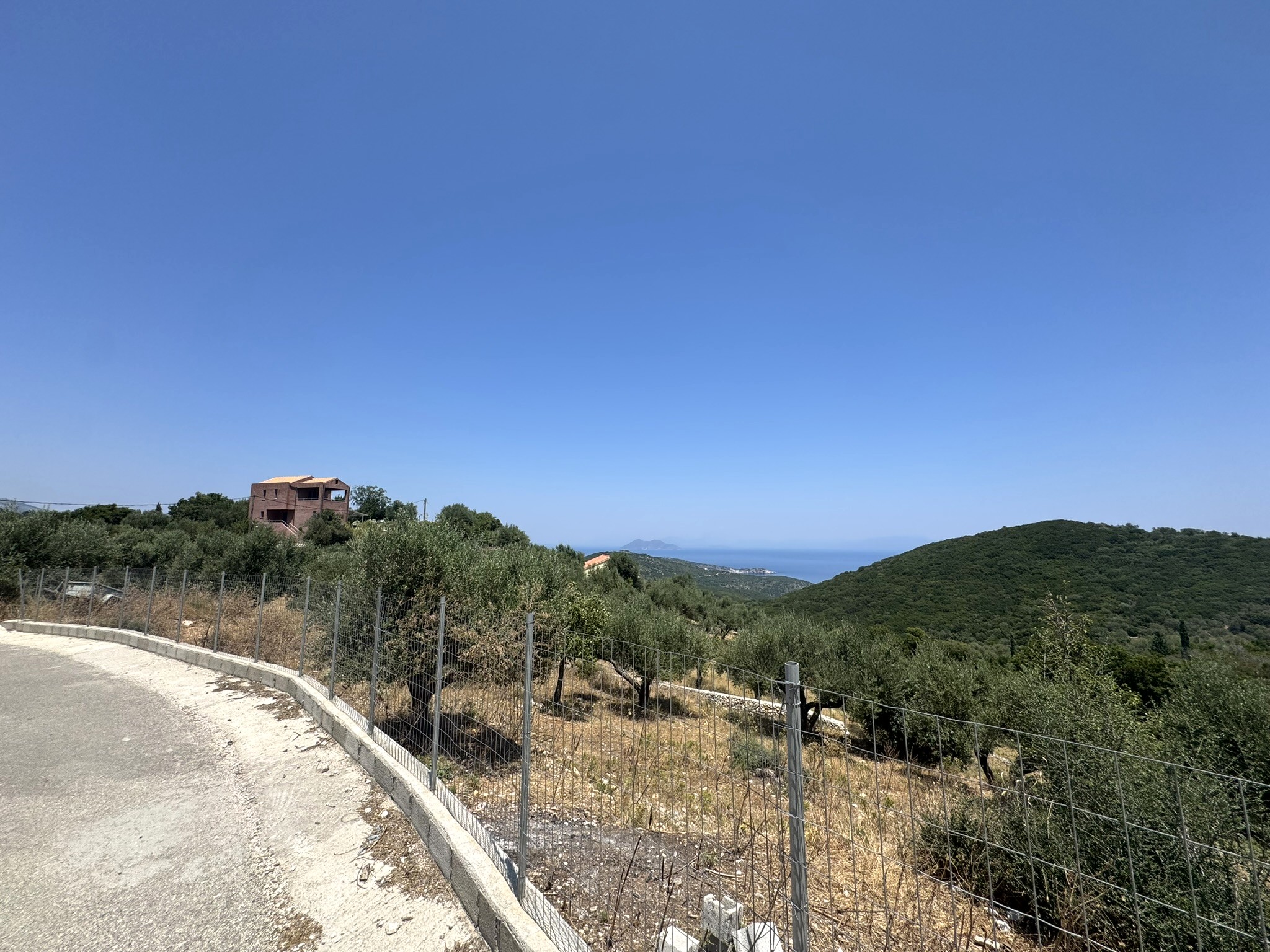 Road view of land with building license for sale in Ithaca Greece, Vathi