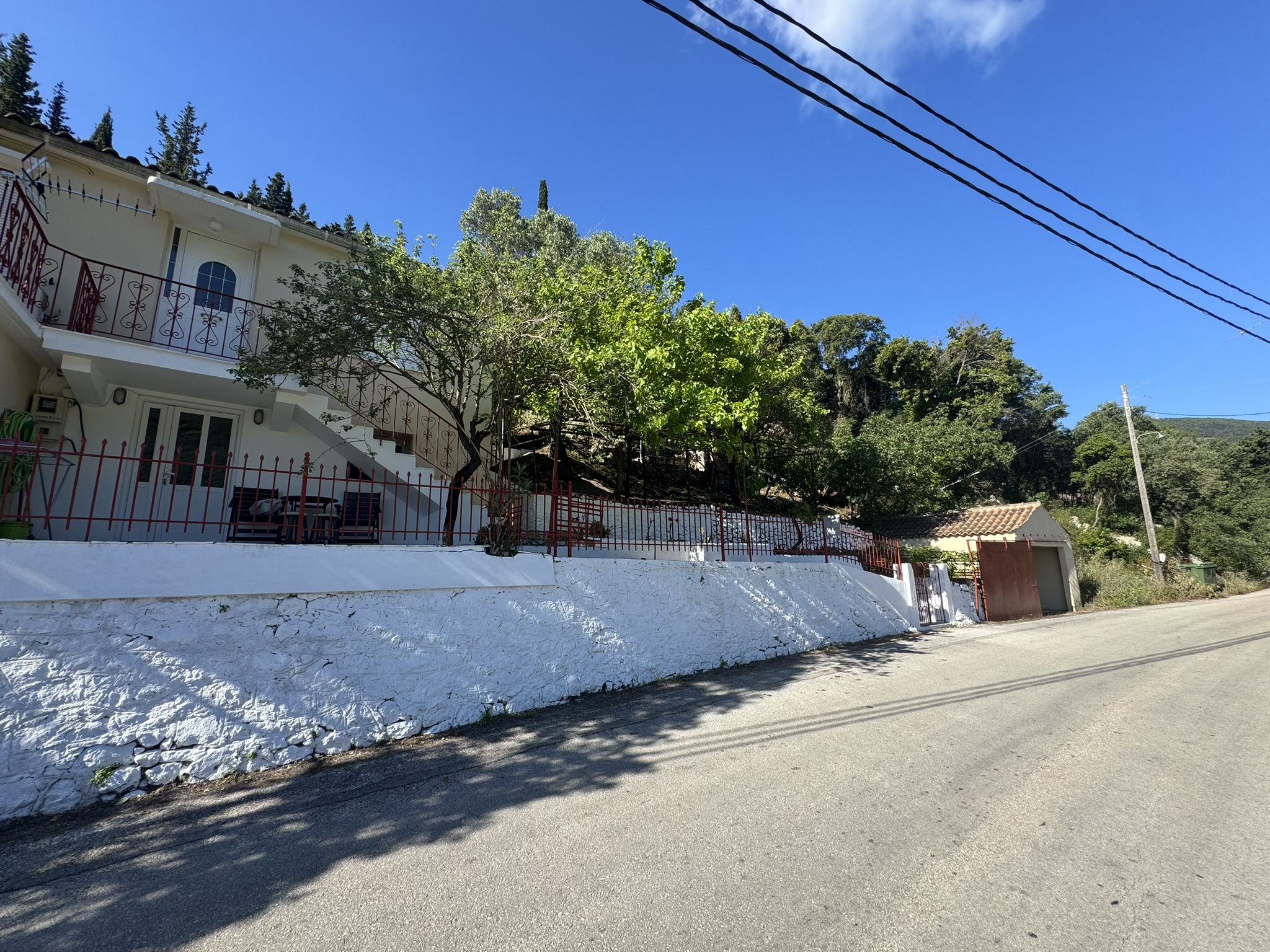 Road view of house for sale in Ithaca Greece Frikes